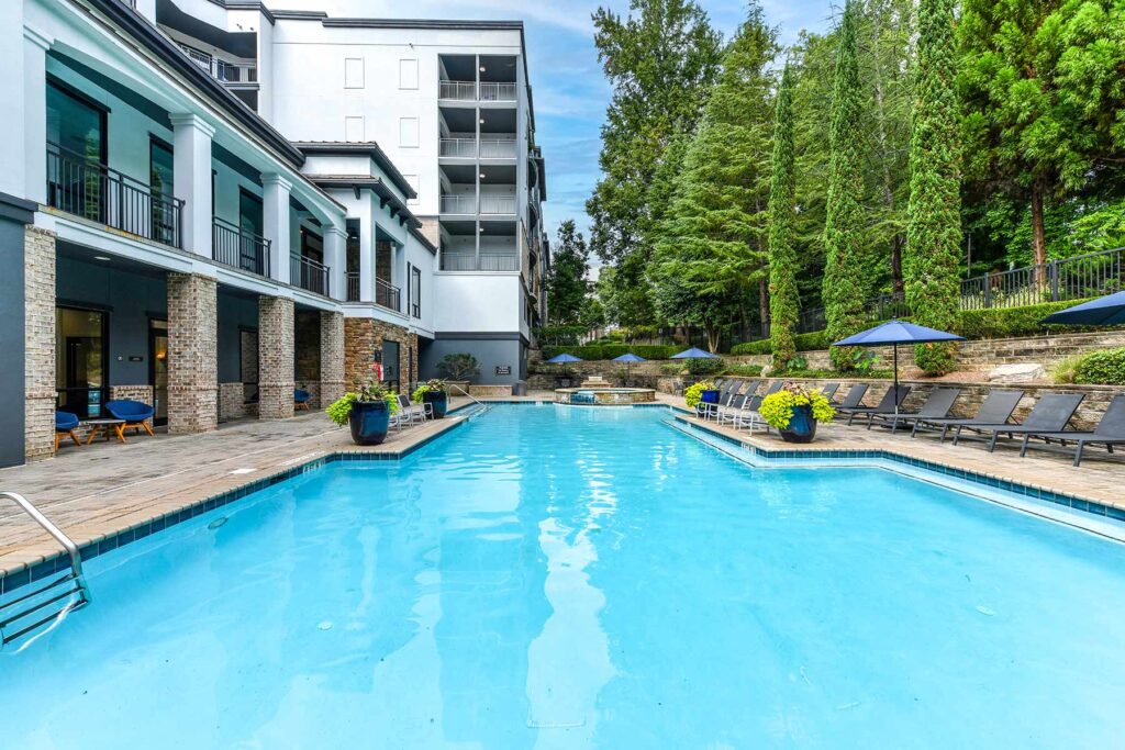 Pool with deck seating and large trees