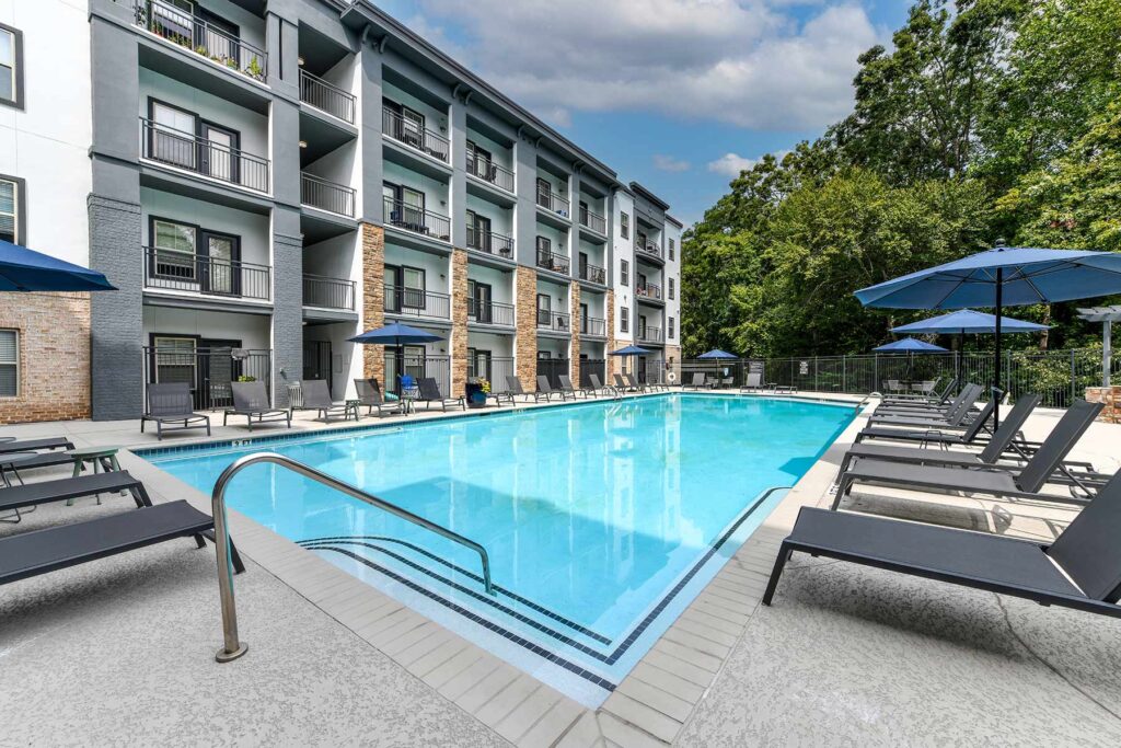 Pool with deck seating and large trees